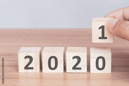 Fototapeta Naklejka Na Ścianę i Meble -  Hand holding wooden blocks with numbers 2021 putting in a row for change year. The beginning of the new year. Happy New Year and holiday concept.