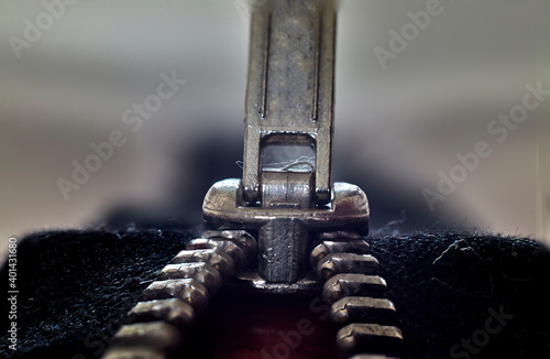 Close-up of a metal zipper, closure on a black fabric