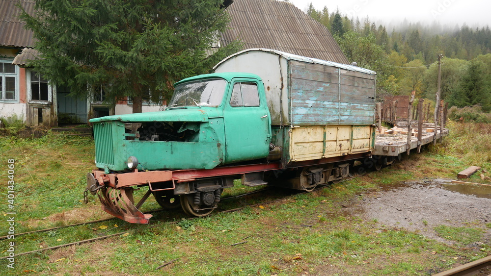 A homemade train with carriages, constructed from a car and a train, stands on the rails, waiting for a ride A homemade train with carriages, constructed from a car and a train, stands on the rails, waiting for a ride