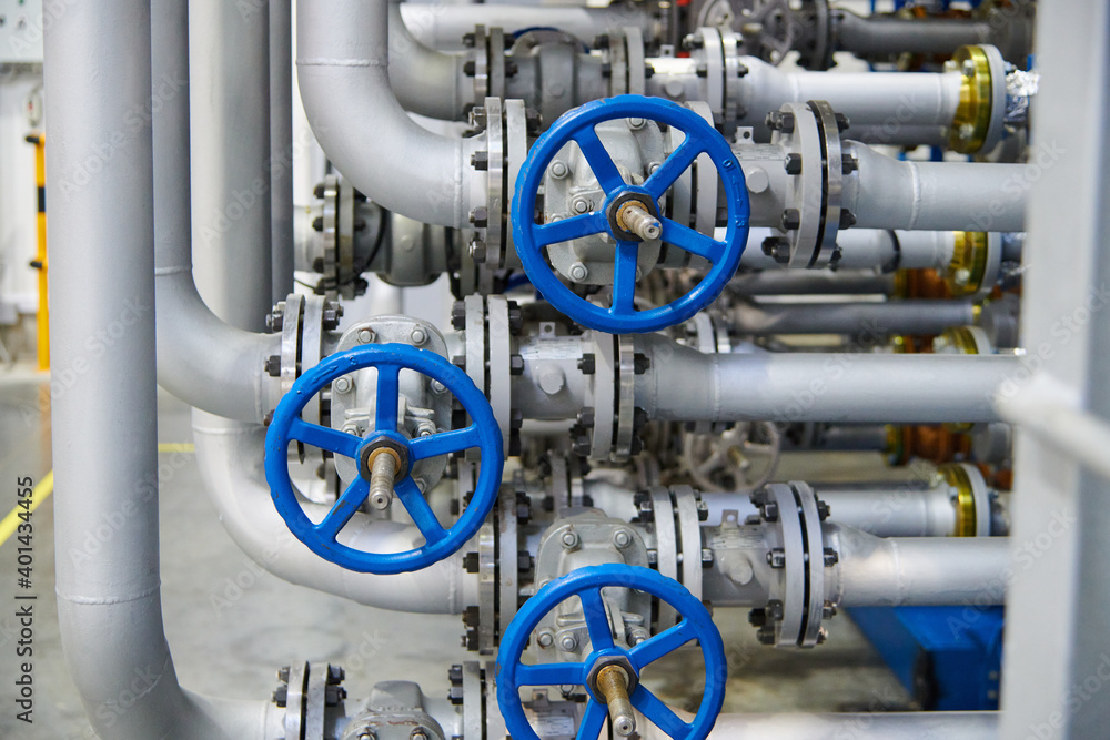 A lot of pipes with valves on a factory A lot of pipes with valves on a factory