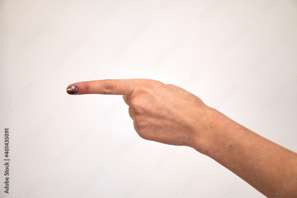Caucasian female hand shows gestures and raises her finger to the side. The finger indicates the direction to the left. Exclamation and attention. Caucasian female hand shows gestures and raises her finger to the side. The finger indicates the direction to the left. Exclamation and attention.