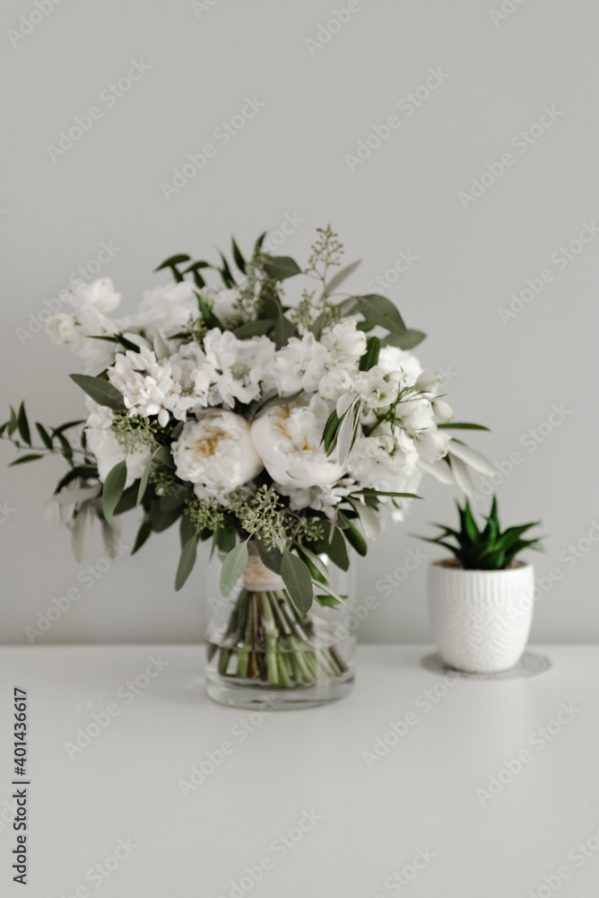 a beautiful wedding bouquet stands in a vase of water. the bride's bouquet. florist. wedding decorations. mothers Day. March 8. flowers a beautiful wedding bouquet stands in a vase of water. the bride's bouquet. florist. wedding decorations. mothers Day. March 8. flowers