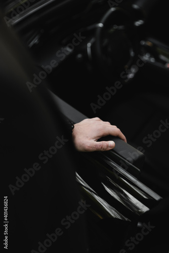 Businessman driving a sports luxury car.Hand on the handle. Close-up of man in formal attire opening car door