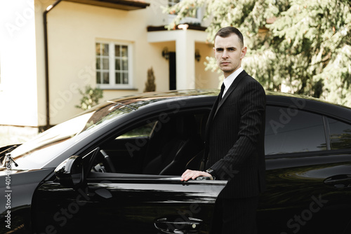 Wallpaper Mural young successful businessman stands in front of his expensive car. rich young guy. rich man. car on the background of a businessman. groom with car on wedding day Torontodigital.ca