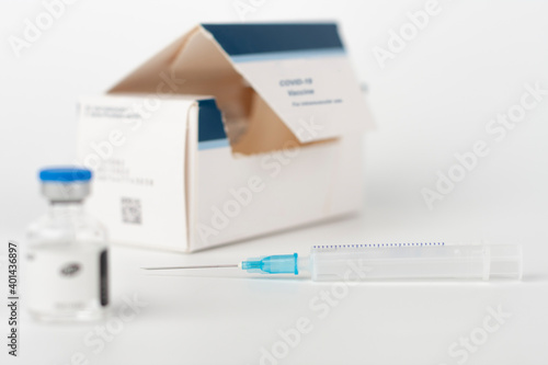 Medical concept, syringe with needle, vial and paper box with Covid-19 Vaccines photo