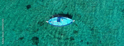 Aerial drone ultra wide photo of traditional fishing boat in Ionian bay with emerald sea, Greece