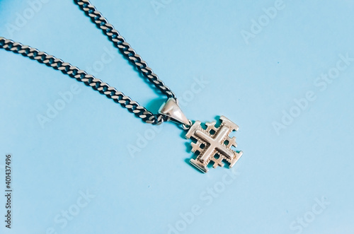 Jerusalem silver crusader cross with chain on a blue background.. photo