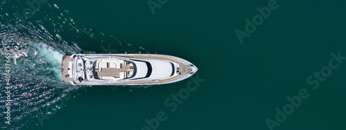 Aerial drone ultra wide photo of luxurious yacht with wooden deck anchored in deep blue Mediterranean Sea