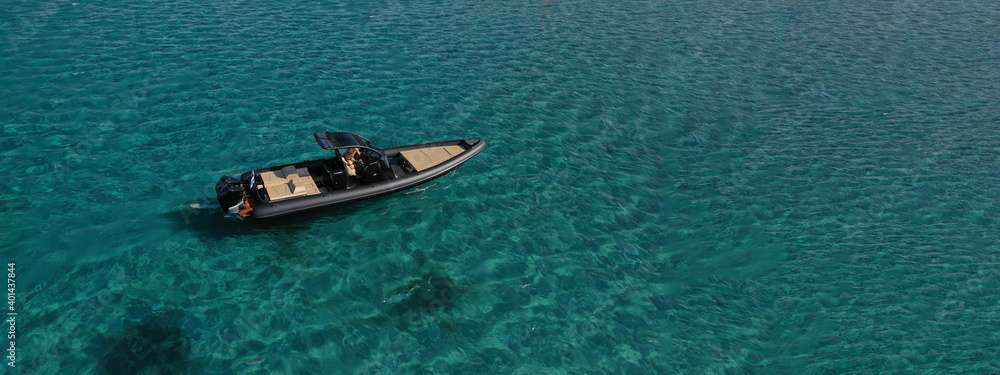 Aerial drone ultra wide photo of inflatable rib power boat anchored in tropical exotic emerald crystal clear sea bay