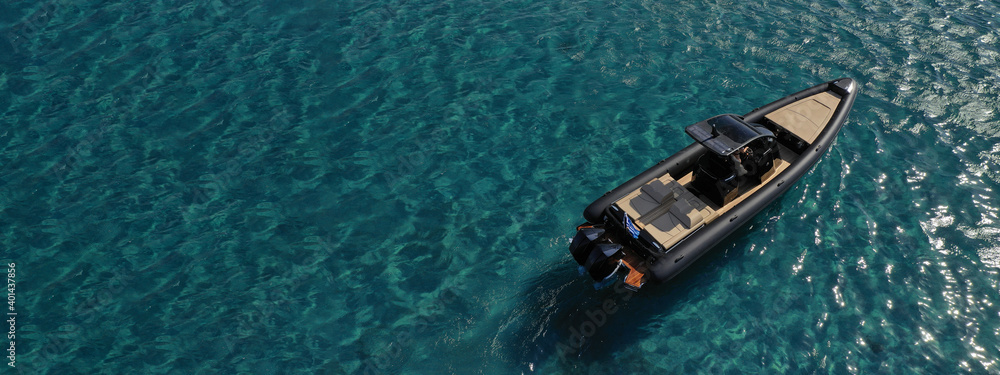 Aerial drone ultra wide photo of inflatable rib power boat anchored in tropical exotic emerald crystal clear sea bay Aerial drone ultra wide photo of inflatable rib power boat anchored in tropical exotic emerald crystal clear sea bay