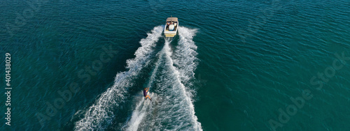Aerial drone ultra wide photo of extreme powerboat water ski cruising in high speed in tropical turquoise bay © aerial-drone