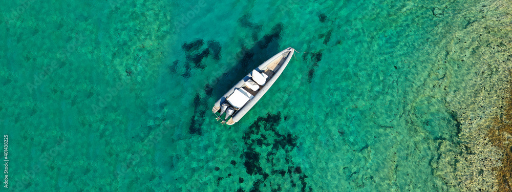 Aerial drone ultra wide photo of inflatable rib power boat cruising in high speed in tropical exotic emerald crystal clear sea bay Aerial drone ultra wide photo of inflatable rib power boat cruising in high speed in tropical exotic emerald crystal clear sea bay