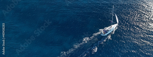 Aerial drone ultra wide photo of sail boat cruising in the deep blue Aegean sea, Greece