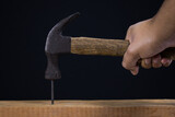 Hammer with nail on black background