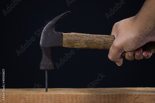 Hammer with nail on black background