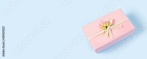 Beautiful pink gift box isolated on blue background. Copy space. Banner. © Lyubov
