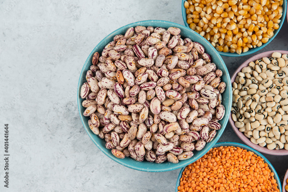 Obraz premium Bunch of various uncooked beans, corns and red lentils on marble surface