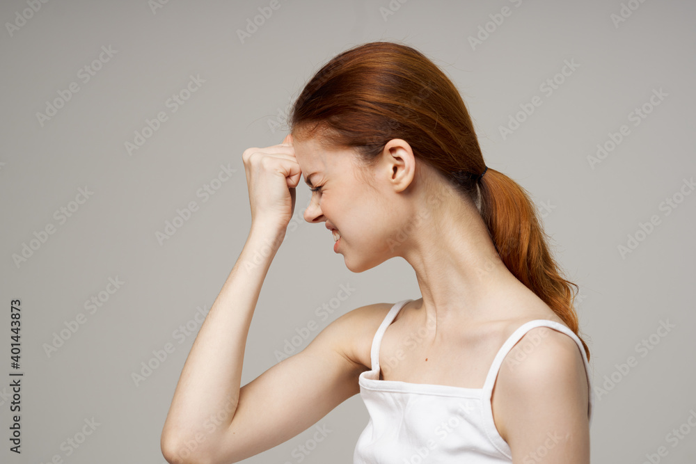 beautiful woman in white t-shirt touching face with hands on gray background health problems headache beautiful woman in white t-shirt touching face with hands on gray background health problems headache
