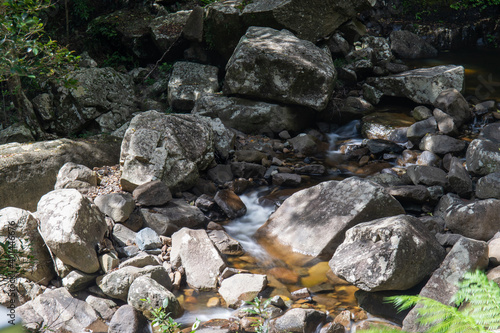Water stream flowing between rocks in the river.