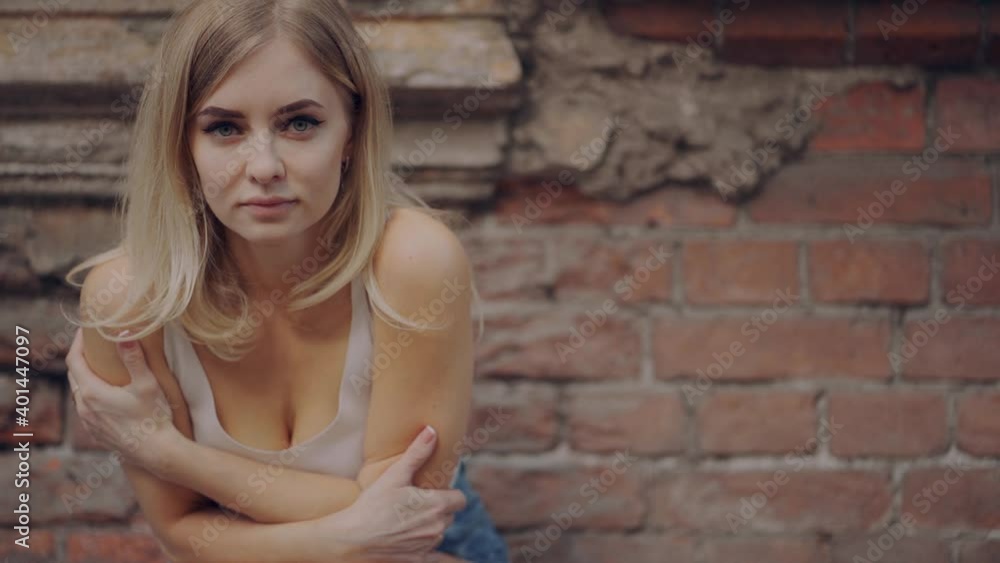 a lonely girl sits near an old building and observes the environment a lonely girl sits near an old building and observes the environment