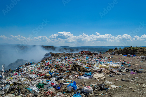 View of garbage field in trash dump or open landfill, food and plastic waste products polluting in a trash dump, Workers hands sorting garbage for recycling. © attraction art