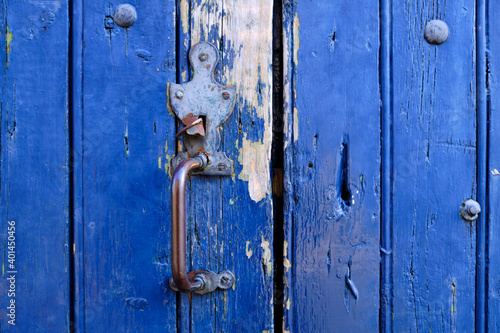 Old metal rustic door handle on a blue wooded door close up of the vintage feature © joseph roland