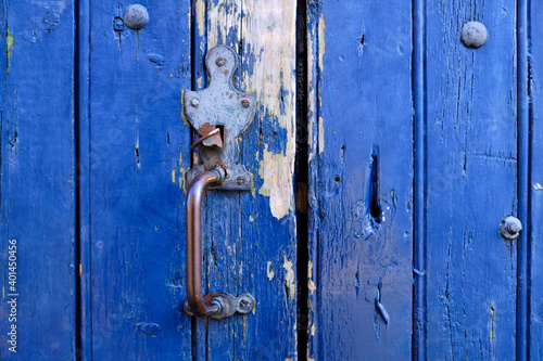 Old metal rustic door handle on a blue wooded door close up of the vintage feature