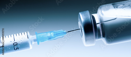 Medical syringe with a needle and a bollte with vaccine.