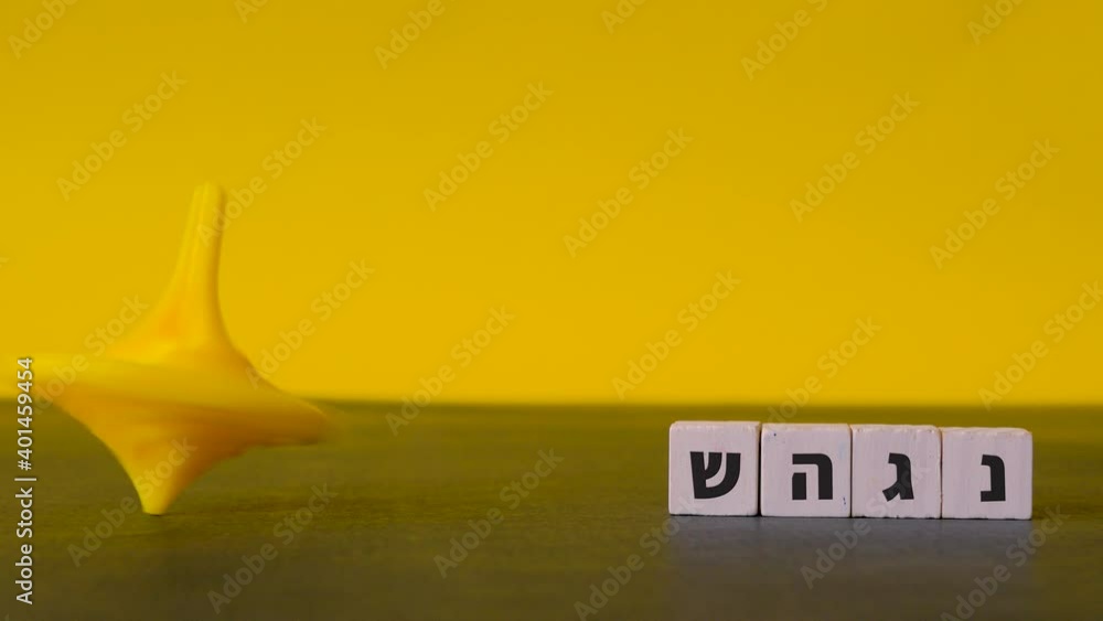 Spinning yellow top Hanukkah careers about beside the four hebrew letters nun, gimel, heh and