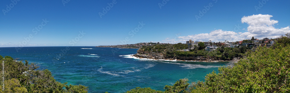 Stunning panoramic view of a deep blue sea and small beach from a coastal trail lookout, Sydney, New South Wales, Australia
