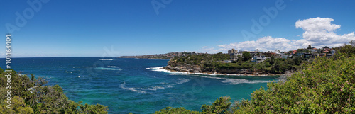 Stunning panoramic view of a deep blue sea and small beach from a coastal trail lookout, Sydney, New South Wales, Australia 
