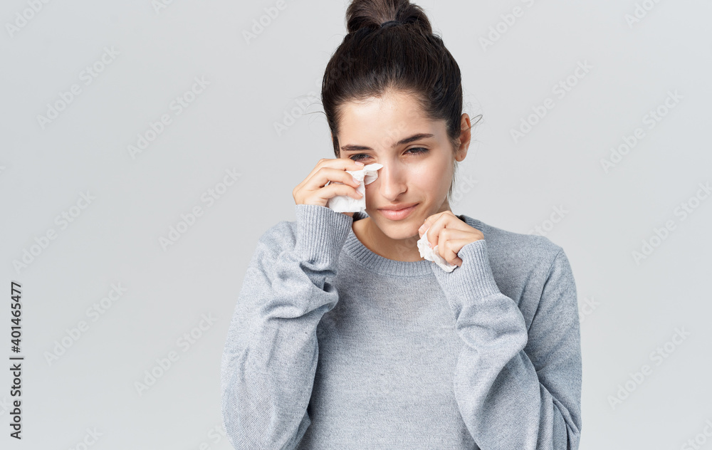 Woman runny nose health problems gray sweater napkin Woman runny nose health problems gray sweater napkin