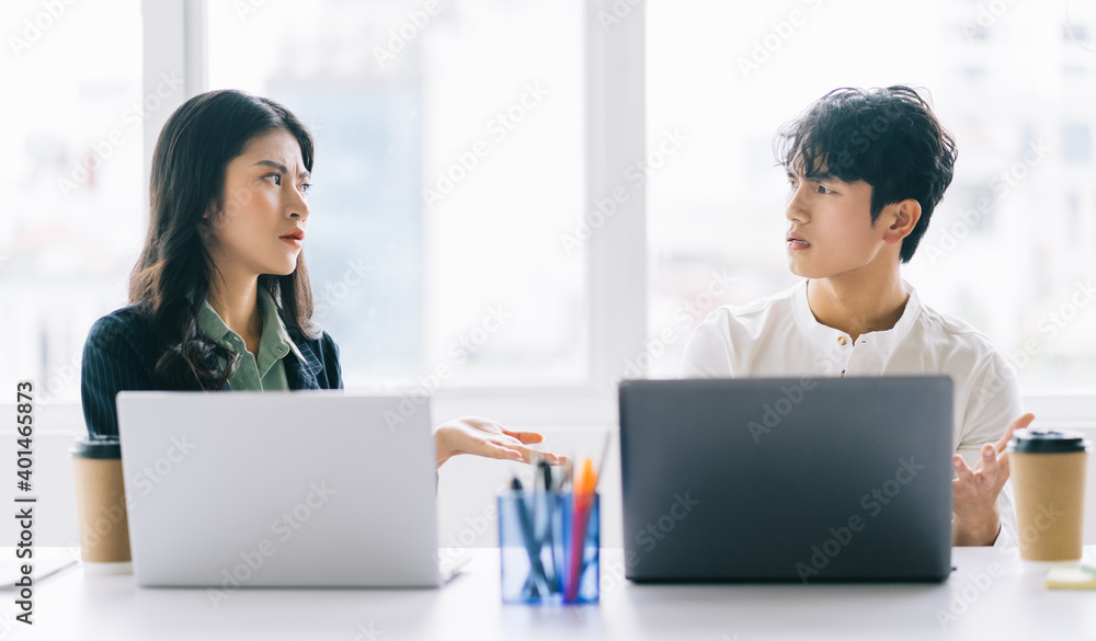 Two young Asian businessmen are debating the year-end project Two young Asian businessmen are debating the year-end project