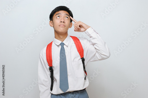 Portrait of smart high school student thinking and look up. Smart high school student wearing uniform thinking and look up