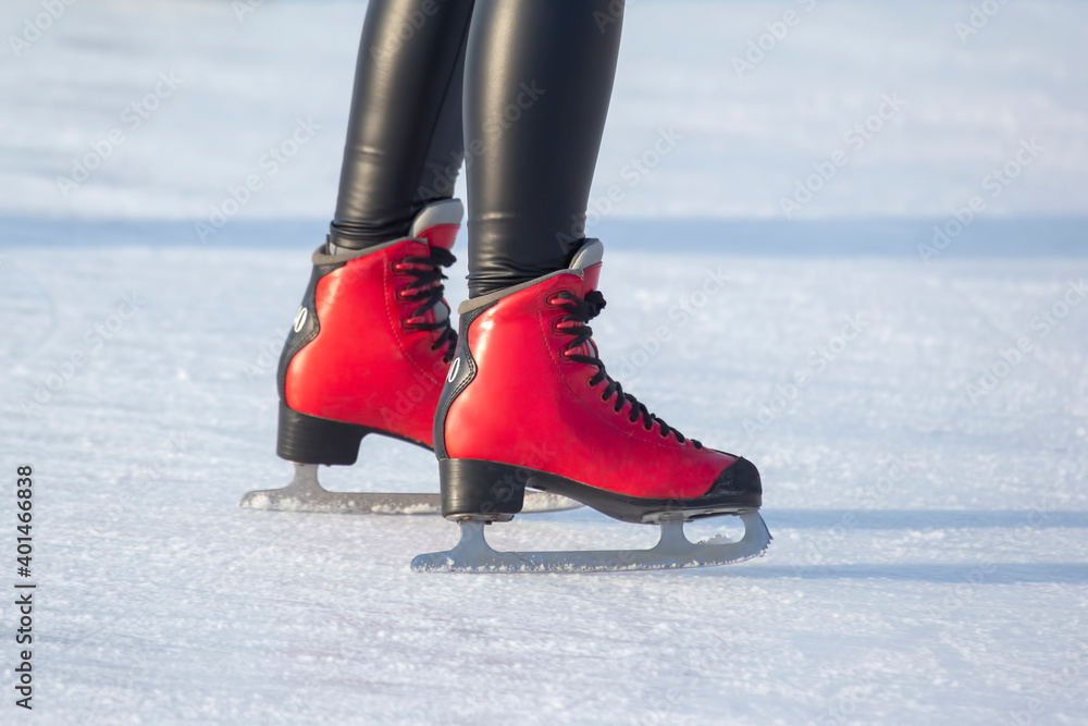 feet in red skates on an ice rink. hobbies and leisure. winter sports feet in red skates on an ice rink. hobbies and leisure. winter sports