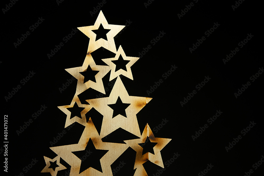 Horizontal conceptual close-up photo of an isolated wooden Christmas tree constructed of stars on the black background Horizontal conceptual close-up photo of an isolated wooden Christmas tree constructed of stars on the black background