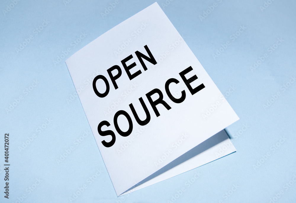 Open source text on a white sheet, on a blue background. A concept photo showing the software whose source code is freely available Open source text on a white sheet, on a blue background. A concept photo showing the software whose source code is freely available