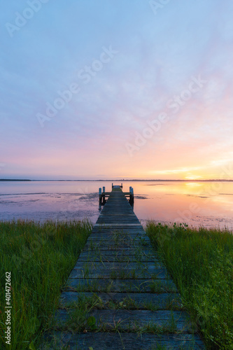 Sunrise view on the lake with wooden jetty.