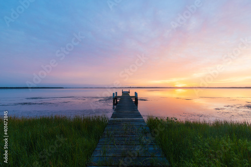 Sunrise view on the lake with wooden jetty.