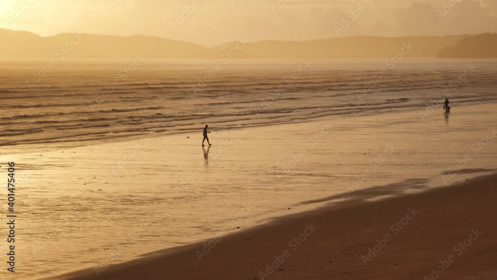 Silhouette people on sand beach in evening, Orange Scene in sunset sky and mountain landscape Silhouette people on sand beach in evening, Orange Scene in sunset sky and mountain landscape