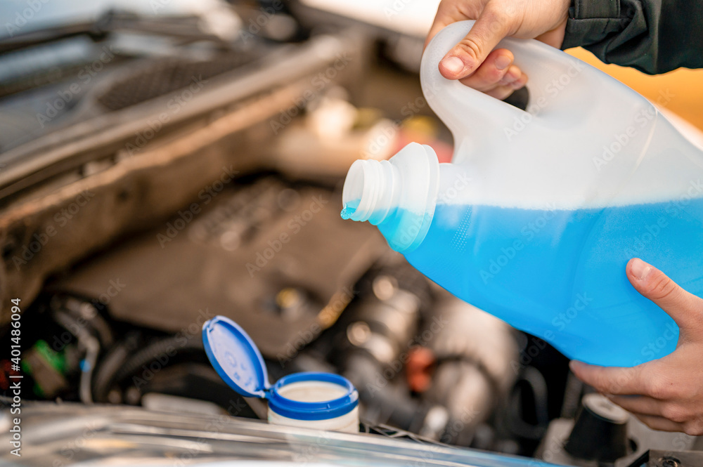 Pouring antifreeze. Filling a windshield washer tank with an antifreeze