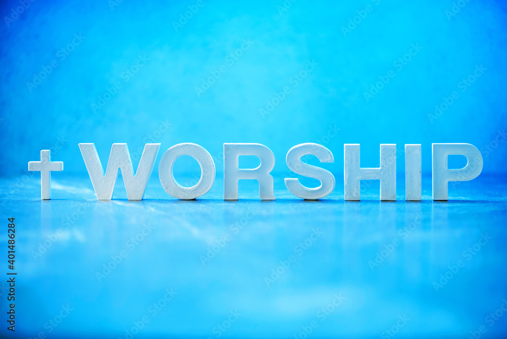 Word Worship made with cement letters on blue marble background. Copy space. Biblical, spiritual or christian reminder. Good friday, Easter day in church. Christian music concert, Sunday service