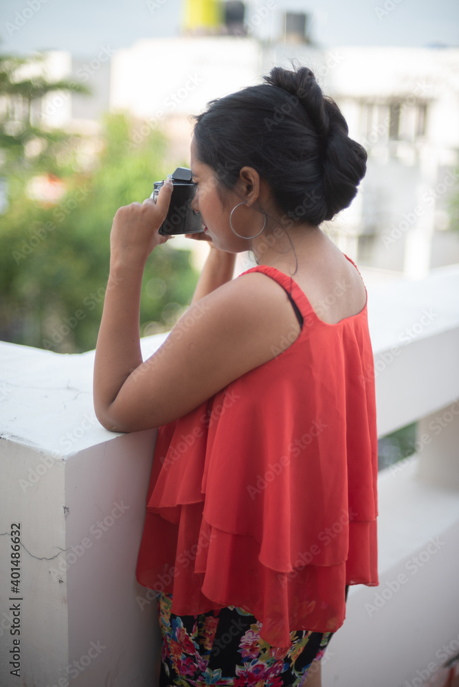 Lifestyle portrait of an Indian Bengali young girl in red casual wear inside Indian household. Indian lifestyle and fashion Lifestyle portrait of an Indian Bengali young girl in red casual wear inside Indian household. Indian lifestyle and fashion