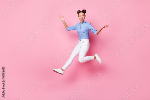Full length body size photo of jumping crazy girl wearing casual clothes laughing isolated on pastel pink color background