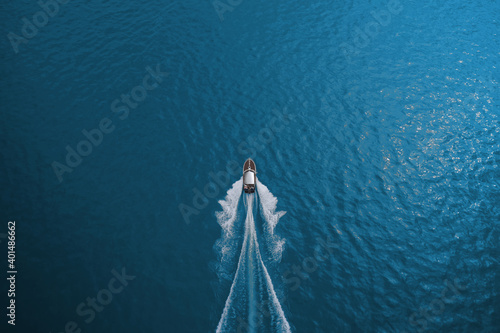 Top view of a boat sailing to the blue sea. Drone view of a boat. Aerial view luxury motor boat. Drone view of a boat the turquoise clear waters. © Berg