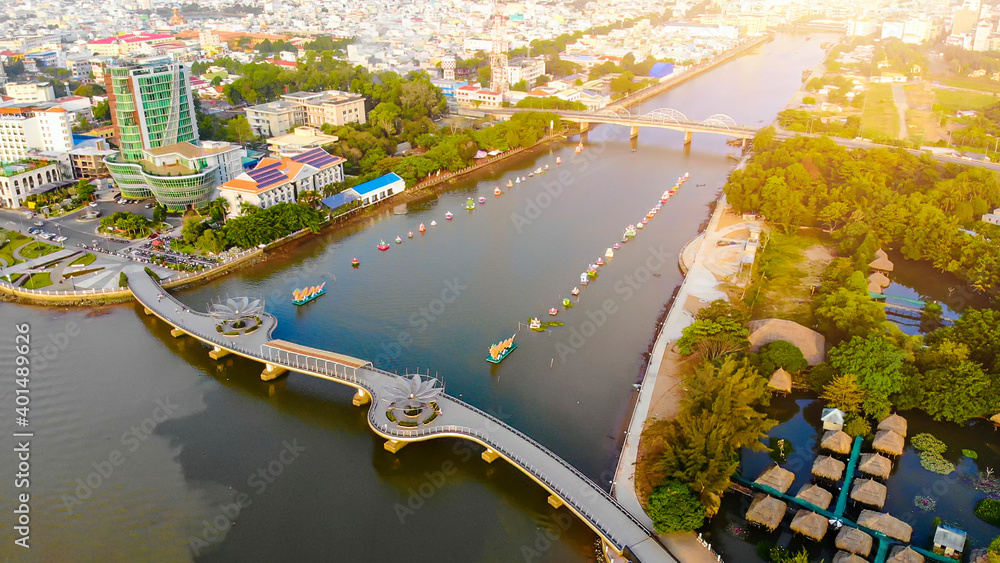 Fototapeta premium Top view aerial view love bridge or Ninh Kieu quay of downtown in Can Tho City, Vietnam with development buildings, transportation, energy power infrastructure