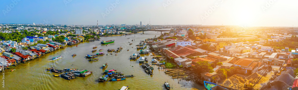 Fototapeta premium Aerial view of Cai Rang floating market, Can Tho, Vietnam. Cai Rang is famous market in mekong delta, Vietnam. Tourists, people buy and sell food, vegetable, fruits on boat, ship