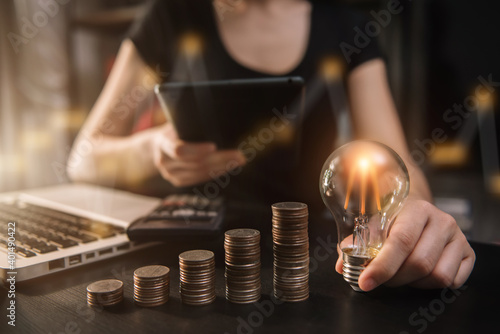 Light bulb with heap of coins stairs for financial plan or business idea concept.