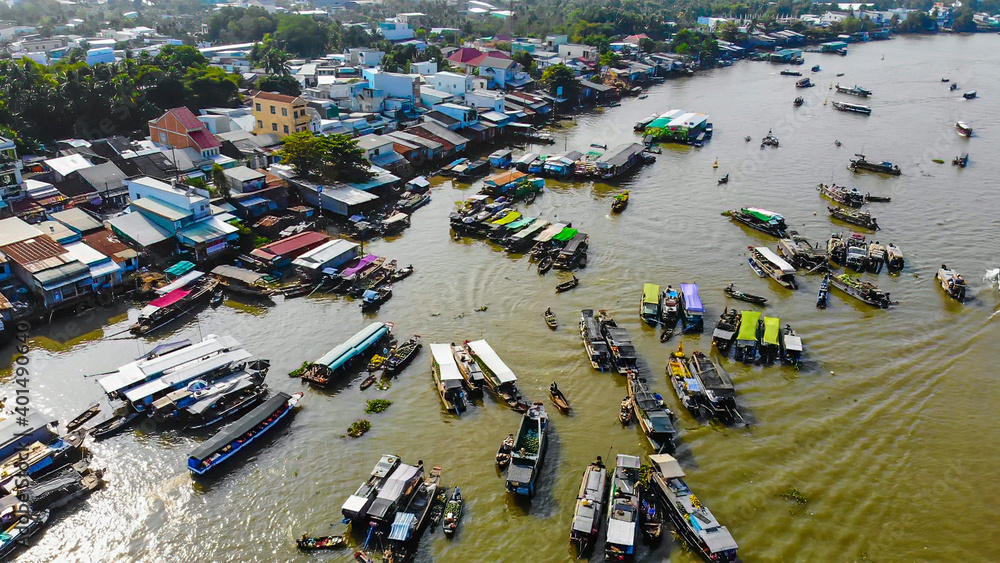 Obraz premium Aerial view of Cai Rang floating market, Can Tho, Vietnam. Cai Rang is famous market in mekong delta, Vietnam. Tourists, people buy and sell food, vegetable, fruits on boat, ship