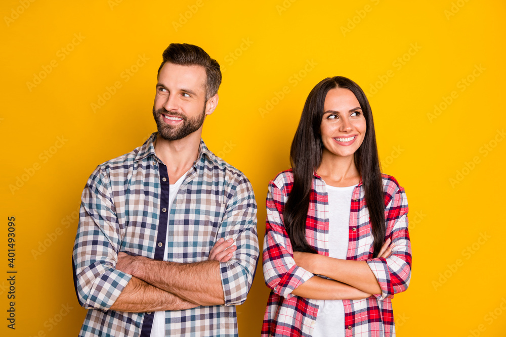 Portrait of attractive cheerful minded couple folded arms thinking clue isolated over bright yellow color background Portrait of attractive cheerful minded couple folded arms thinking clue isolated over bright yellow color background